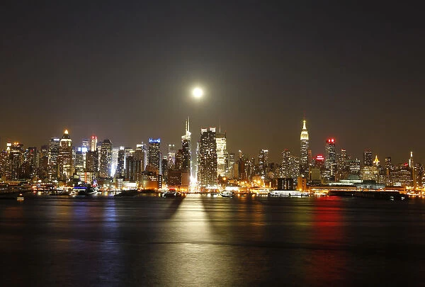 File photo of a full moon rising over the New York skyline above 42nd Street, seen