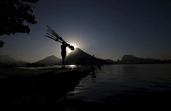 A rowing athlete carries paddles ahead of training session at the World Rowing Junior