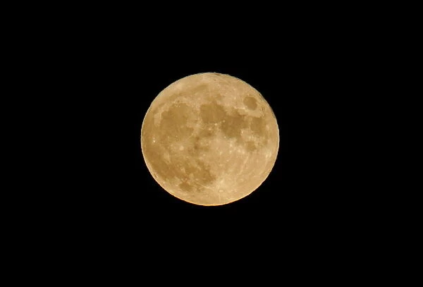 A seasonal full moon, known as the 'blue moon', rises over the sky of I Faraglioni di