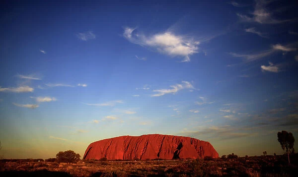 Uluru is lit by the setting sun in the Northern Territory in central Australia