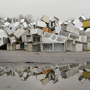 Disused fridges and freezers lie piled up in a storage yard in Manchester
