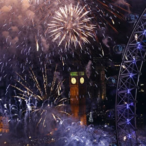Fireworks explode beside the London Eye and The Houses of Parliament on the River