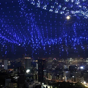 A light display of the Milky Way is reflected on a window as skyscrapers and the Tokyo