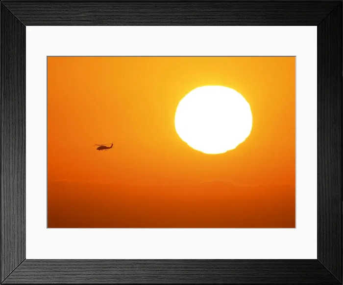 Framed Print : A U. S. military helicopter travels over the pacific ocean past a setting sun near Cardiff Framed Print : A U. S. military helicopter travels over the pacific ocean past a setting sun near Cardiff