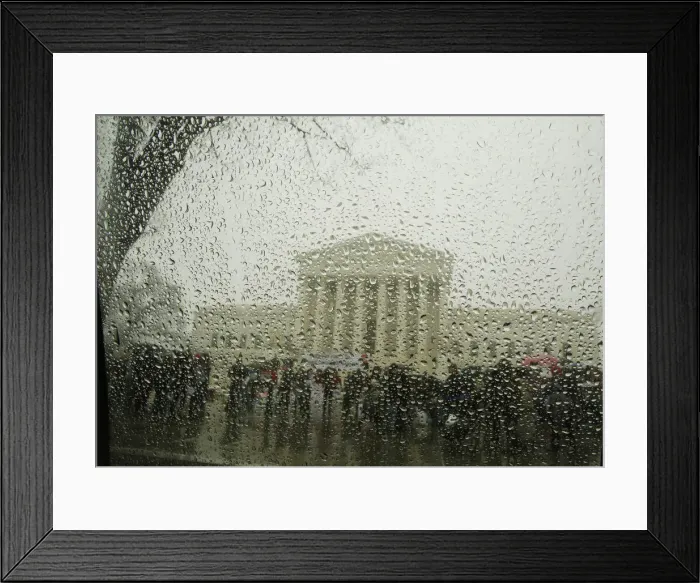 Framed Print : The Supreme Court is seen from within a car as snow melts on the window during a light Framed Print : The Supreme Court is seen from within a car as snow melts on the window during a light