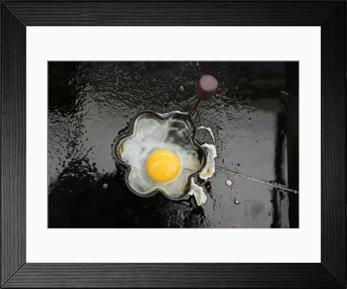 Framed Print : A fried egg is seen on a grill in a roadside snack cafe along the A49 near Tittensor Framed Print : A fried egg is seen on a grill in a roadside snack cafe along the A49 near Tittensor