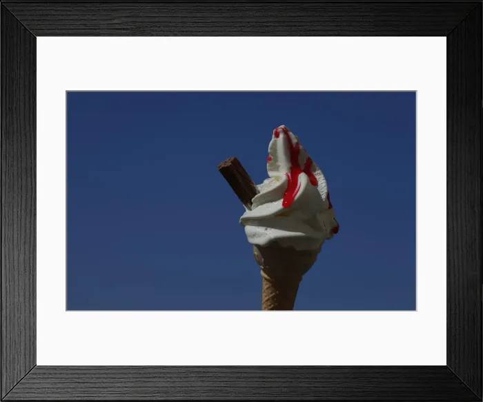 Framed Print : An ice cream cone is held against a blue sky in Blackpool Framed Print : An ice cream cone is held against a blue sky in Blackpool