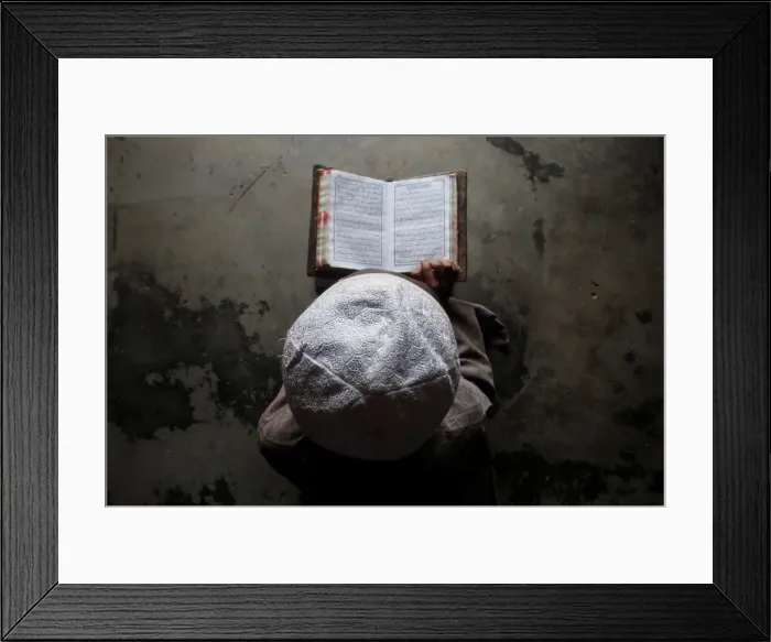 Framed Print : A Muslim boy learns to read the Koran at a madrassa, or religious school, during Framed Print : A Muslim boy learns to read the Koran at a madrassa, or religious school, during
