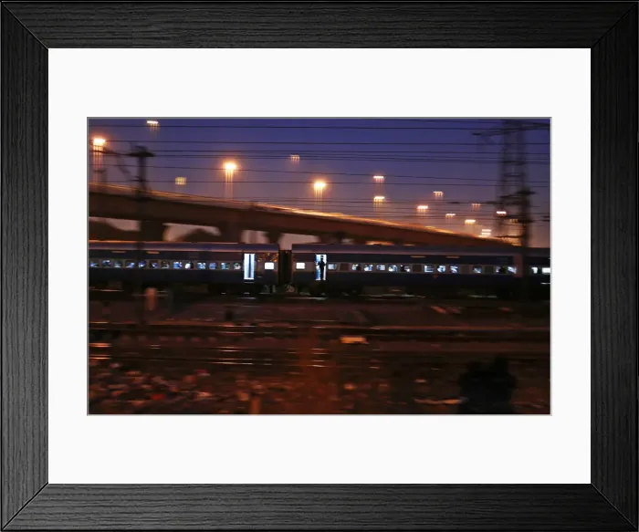 Framed Print : A commuter stands on the doorsteps of a moving train in New Delhi Framed Print : A commuter stands on the doorsteps of a moving train in New Delhi