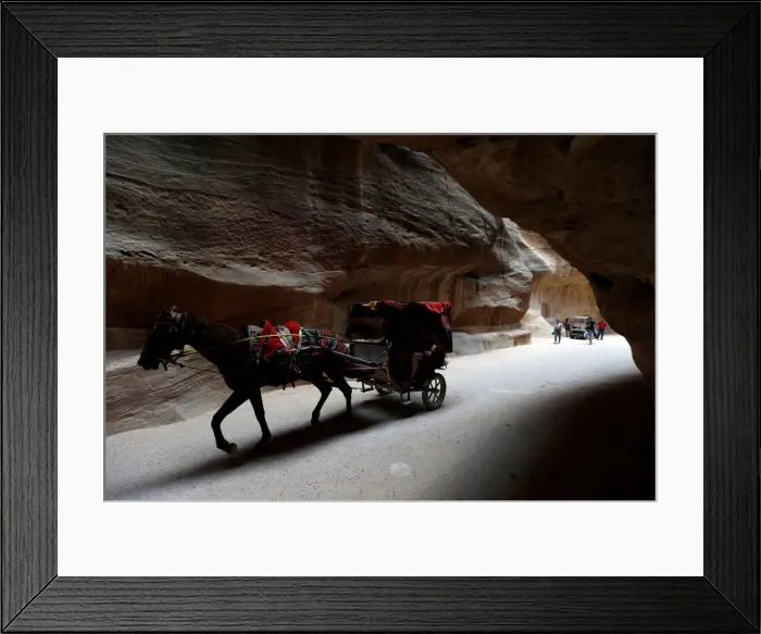 Framed Print : Tourists ride a horse-drawn cart during a tour in the ancient city of Petra, south of Amman Framed Print : Tourists ride a horse-drawn cart during a tour in the ancient city of Petra, south of Amman