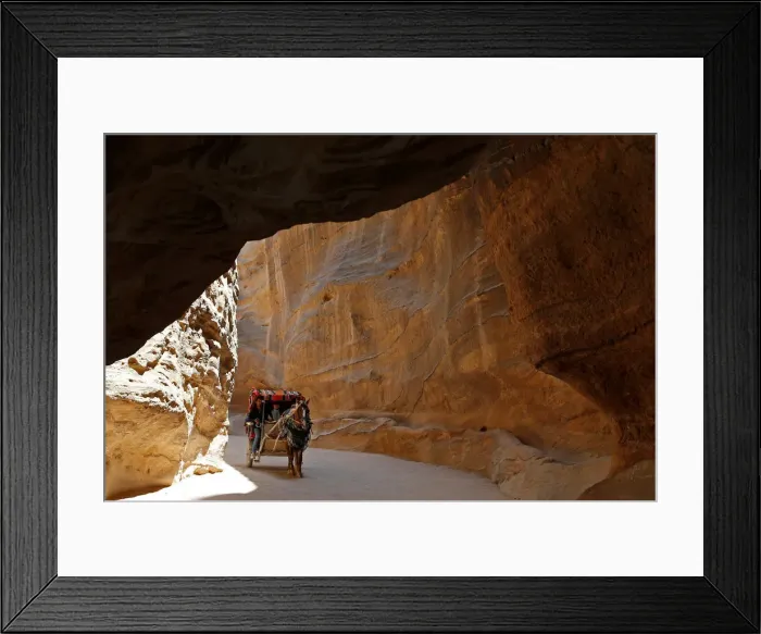 Framed Print : Tourists sit in a horse-drawn cart during a tour in the ancient city of Petra, south