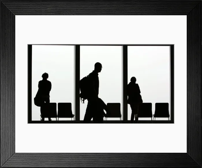 Framed Print : Visitors is silhouetted against a cloudy sky on the observation deck of a skyscraper