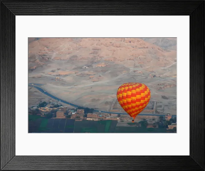 Framed Print : A hot-air balloon flies over the village of al-Qurna, situated over a necropolis of Framed Print : A hot-air balloon flies over the village of al-Qurna, situated over a necropolis of