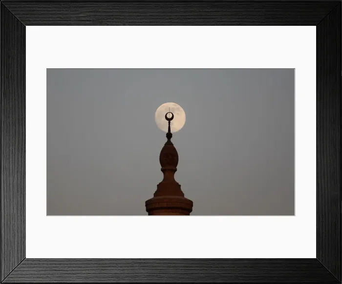 Framed Print : The full Moon rises over a minaret of a mosque during sunset on the 12th day of Framed Print : The full Moon rises over a minaret of a mosque during sunset on the 12th day of
