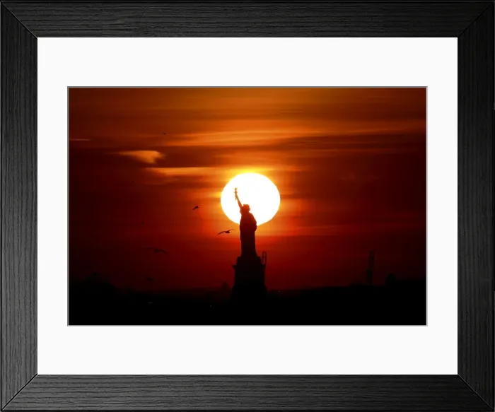 Framed Print : The sun sets behind the Statue of Liberty in New Yorks Harbor as seen from the Brooklyn Framed Print : The sun sets behind the Statue of Liberty in New Yorks Harbor as seen from the Brooklyn