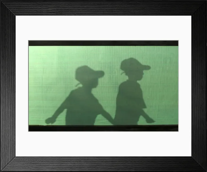 Framed Print : The silhouettes of Palestinian boys are seen as they arrive for a summer camp organised
