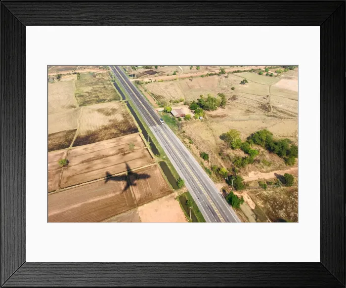 Framed Print : A shadow of a plane is seen near a highway road before landing at Roi Et airport Framed Print : A shadow of a plane is seen near a highway road before landing at Roi Et airport