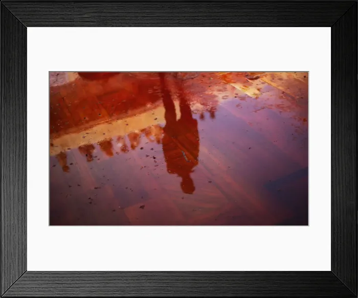 Framed Print : Man casts a reflection on the floor covered with red coloured water during Huranga