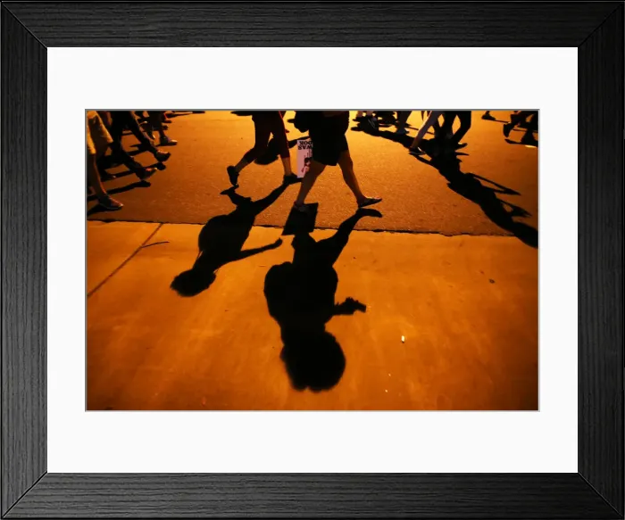 Framed Print : Protesters shadows mark the sidewalk as they march during another night of protests