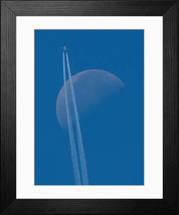 Framed Print : A passenger plane flies in the sky as the Moon is seen in Berlin