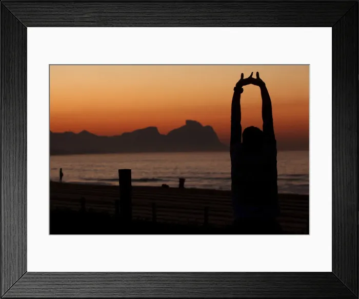 Framed Print : An athlete stretches in front of Recreio dos Bandeirantes beach before the Rio de