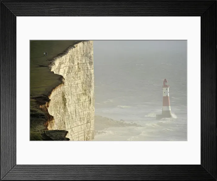 Framed Print : Walkers look out over Beachy Head lighthouse and heavy seas in the English Channel Framed Print : Walkers look out over Beachy Head lighthouse and heavy seas in the English Channel