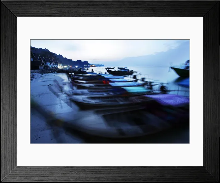 Framed Print : Traditional Thai fishing boats are swayed by small waves as they are anchored on a Framed Print : Traditional Thai fishing boats are swayed by small waves as they are anchored on a