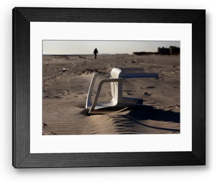 Framed Print : A chair is seen lying in the sand on the beach as a silhouette of a man walks in Atlantic Framed Print : A chair is seen lying in the sand on the beach as a silhouette of a man walks in Atlantic