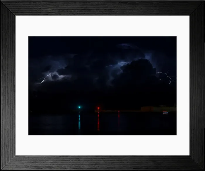 Framed Print : A lightning storm is seen beyond the entrance to Vallettas Grand Harbour Framed Print : A lightning storm is seen beyond the entrance to Vallettas Grand Harbour