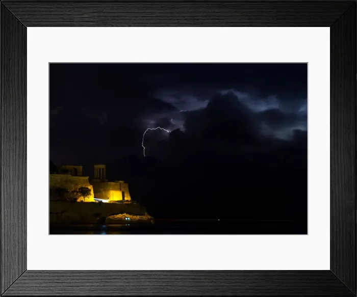 Framed Print : A lightning storm is seen beyond the entrance to Vallettas Grand Harbour Framed Print : A lightning storm is seen beyond the entrance to Vallettas Grand Harbour
