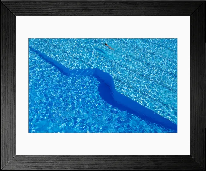 Framed Print : A woman swims in a public pool as temperatures reach new record highs in Hanau