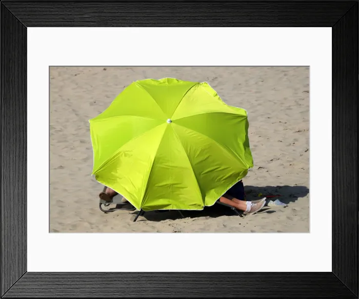 Framed Print : People stay under umbrellas during a hot summer day in Blankenberge Framed Print : People stay under umbrellas during a hot summer day in Blankenberge