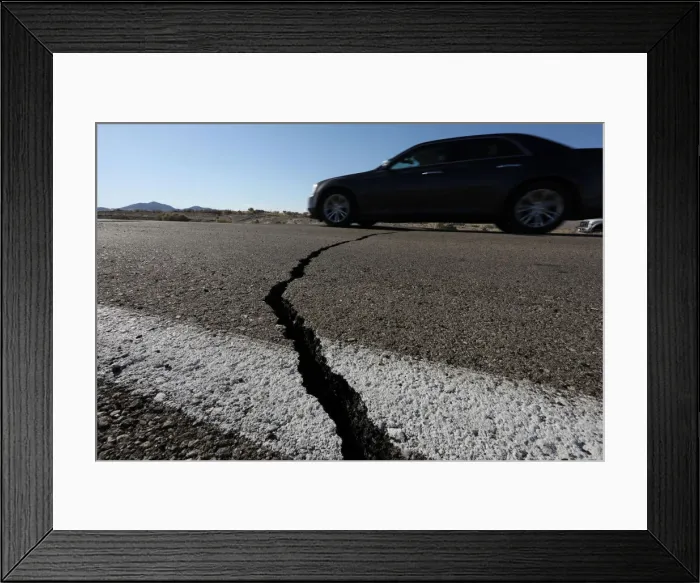 Framed Print : A car passes over a fissure that opened on a highway during a powerful earthquake that Framed Print : A car passes over a fissure that opened on a highway during a powerful earthquake that