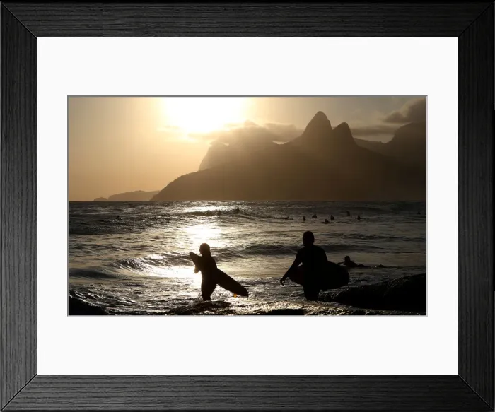 Framed Print : Surfers are seen during a sunset on Arpoador beach in Rio de Janeiro Framed Print : Surfers are seen during a sunset on Arpoador beach in Rio de Janeiro