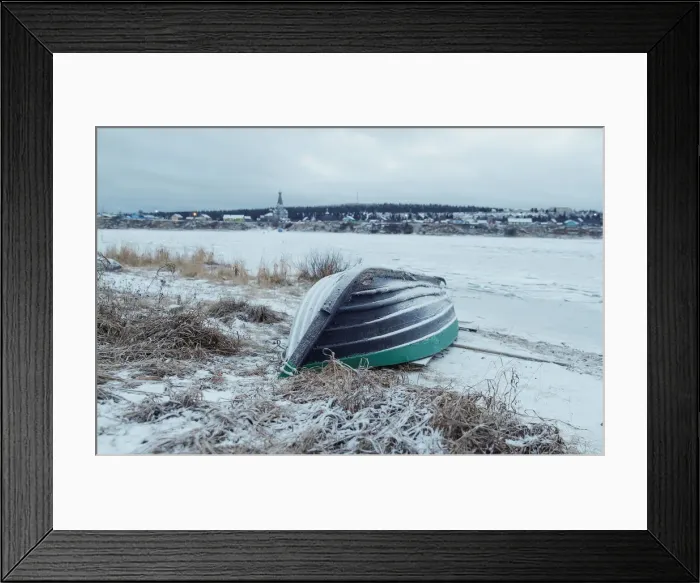 Framed Print : A wooden boat is seen on a bank of frozen Varzuga river in the village of Varzuga in Framed Print : A wooden boat is seen on a bank of frozen Varzuga river in the village of Varzuga in