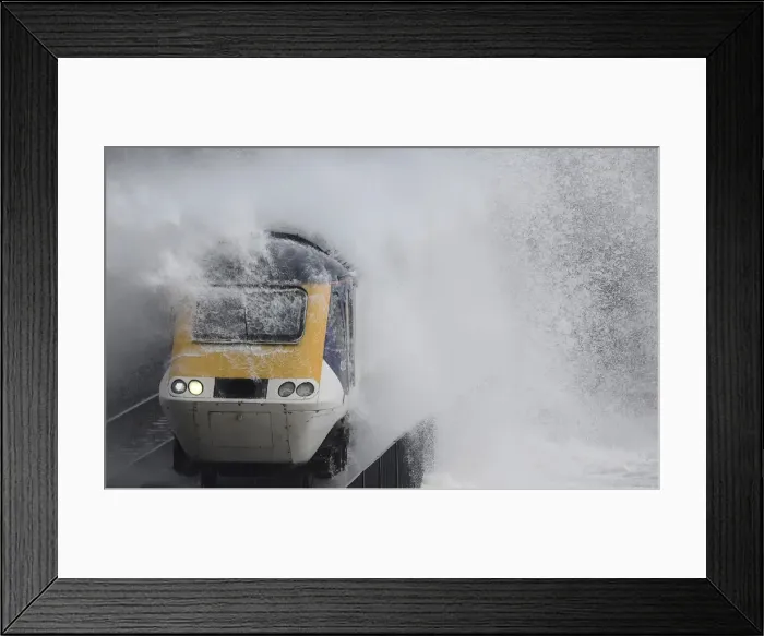 Framed Print : Waves hit a train during heavy seas and high winds in Dawlish in south west Britain Framed Print : Waves hit a train during heavy seas and high winds in Dawlish in south west Britain