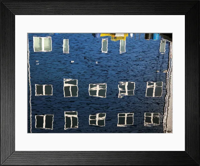 Framed Print : Windows take on different shapes as they reflect upon the water along a wharf in Portland
