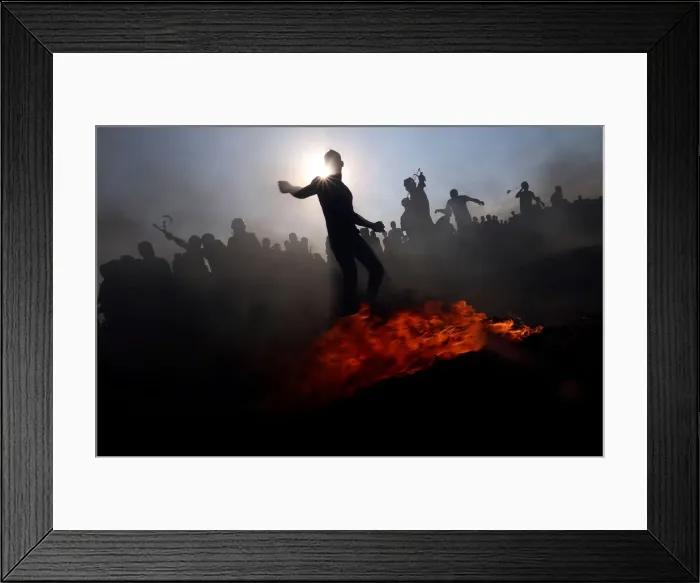 Framed Print : Palestinian demonstrators hurl stones at Israeli troops during a protest at the border Framed Print : Palestinian demonstrators hurl stones at Israeli troops during a protest at the border