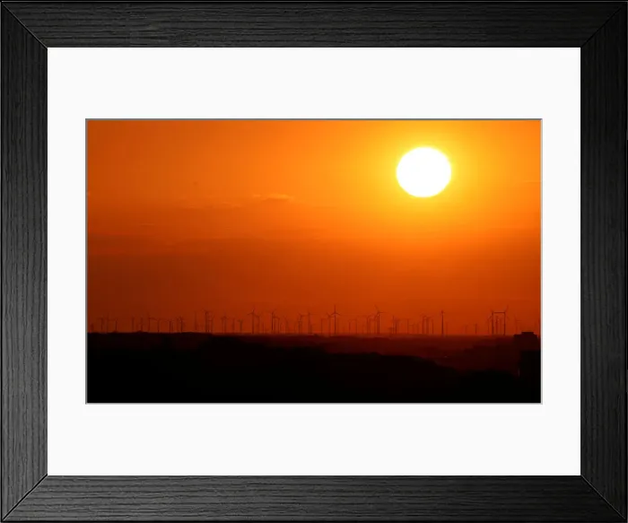 Framed Print : Power-generating windmill turbines are pictured during sunset from the Drachenberg hill