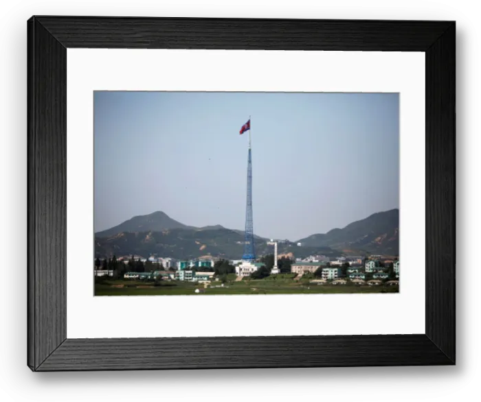 Framed Print : A North Korean flag flutters on top of a tower at the propaganda village of Gijungdong in Framed Print : A North Korean flag flutters on top of a tower at the propaganda village of Gijungdong in