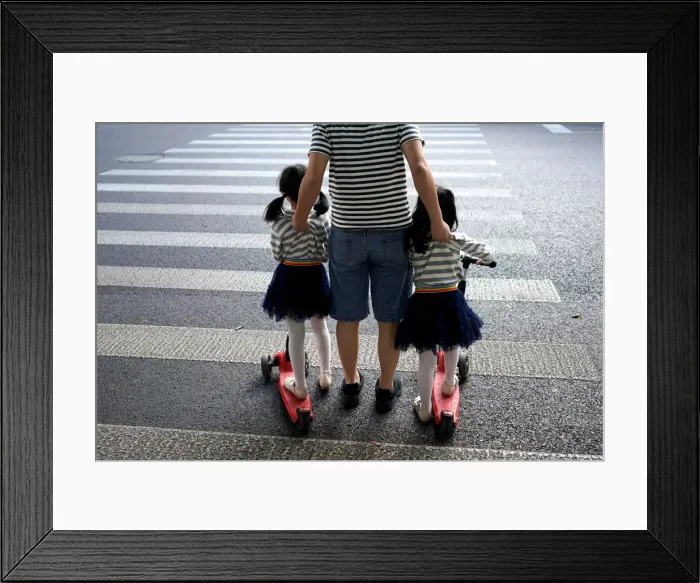 Framed Print : A father crosses a road with his twin daughters in Shanghai Framed Print : A father crosses a road with his twin daughters in Shanghai