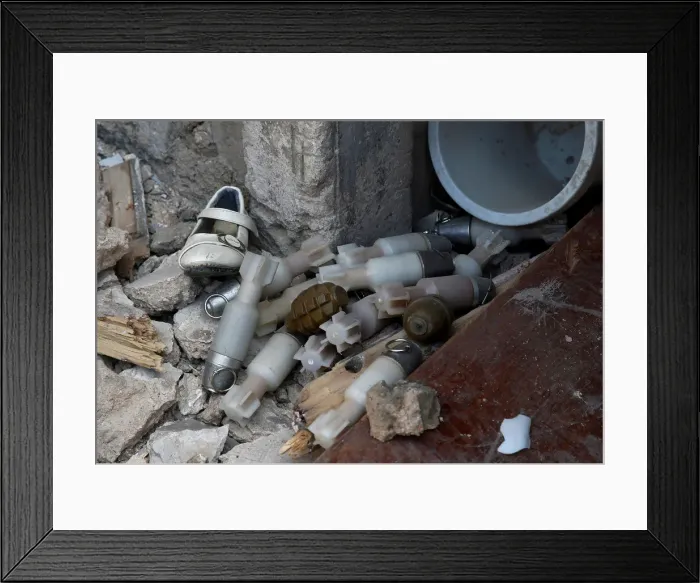 Framed Print : A shoe is seen among a pile of unexploded ordnance at the positions of the Iraqi forces Framed Print : A shoe is seen among a pile of unexploded ordnance at the positions of the Iraqi forces