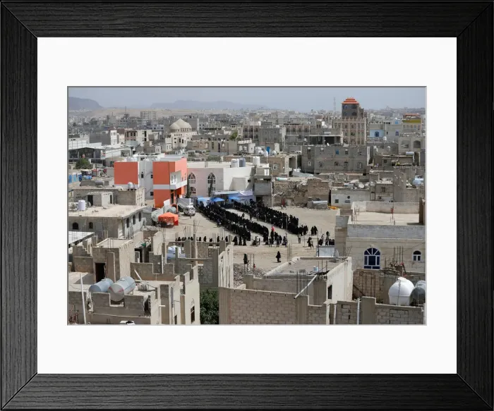 Framed Print : Women and girls queue outside a charity food distribution center to get the iftar meal