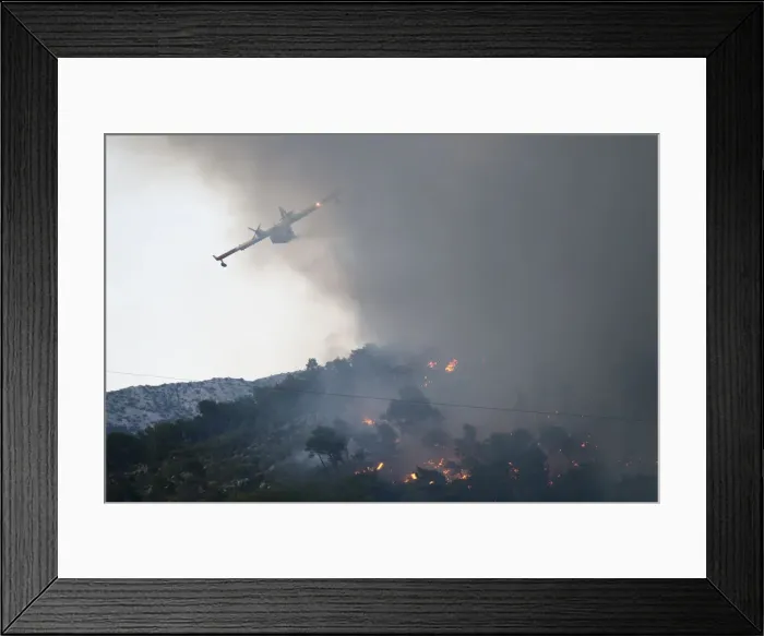 Framed Print : A firefighting plane drops water to extinguish a wildfire in the village of Mravince near Framed Print : A firefighting plane drops water to extinguish a wildfire in the village of Mravince near