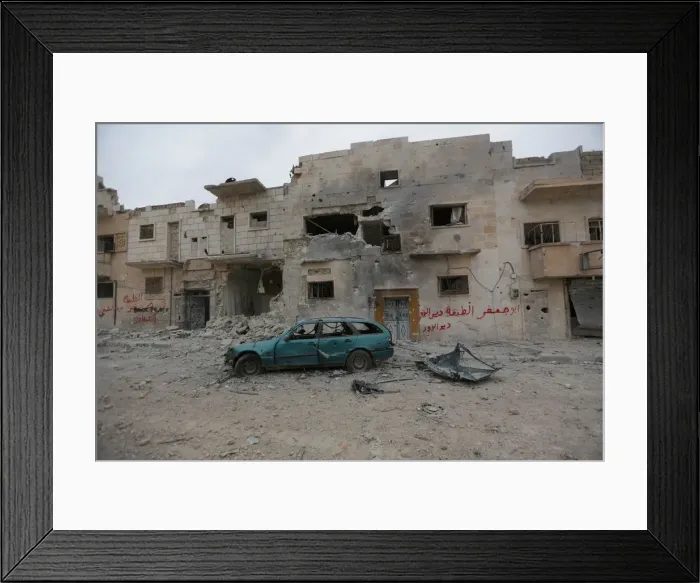 Framed Print : A damaged vehicle is seen near buildings in the northern Syrian town of al-Bab Framed Print : A damaged vehicle is seen near buildings in the northern Syrian town of al-Bab