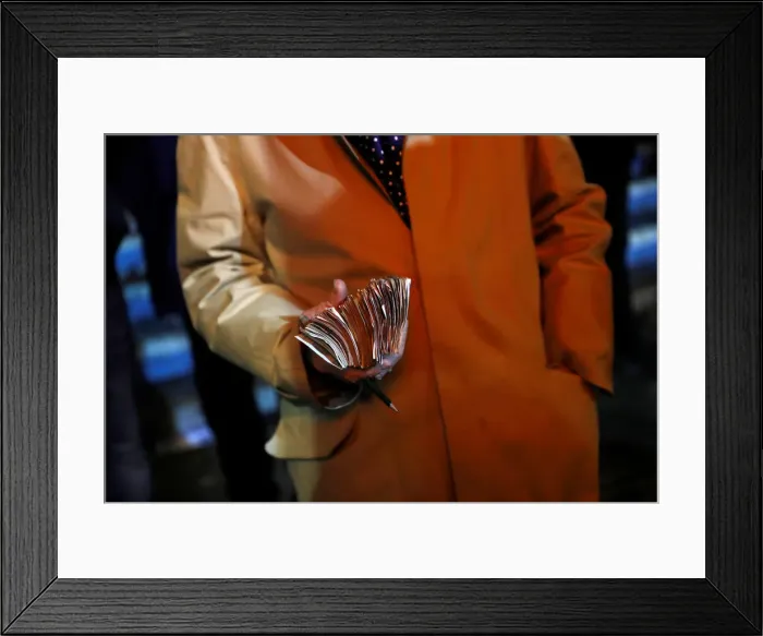 Framed Print : A bookmaker holds money before a greyhound race at Wimbledon Stadium in London Framed Print : A bookmaker holds money before a greyhound race at Wimbledon Stadium in London