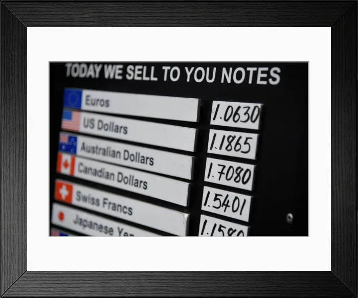 Framed Print : A board displaying buying and selling rates is seen outside of a currency exchange outlet Framed Print : A board displaying buying and selling rates is seen outside of a currency exchange outlet