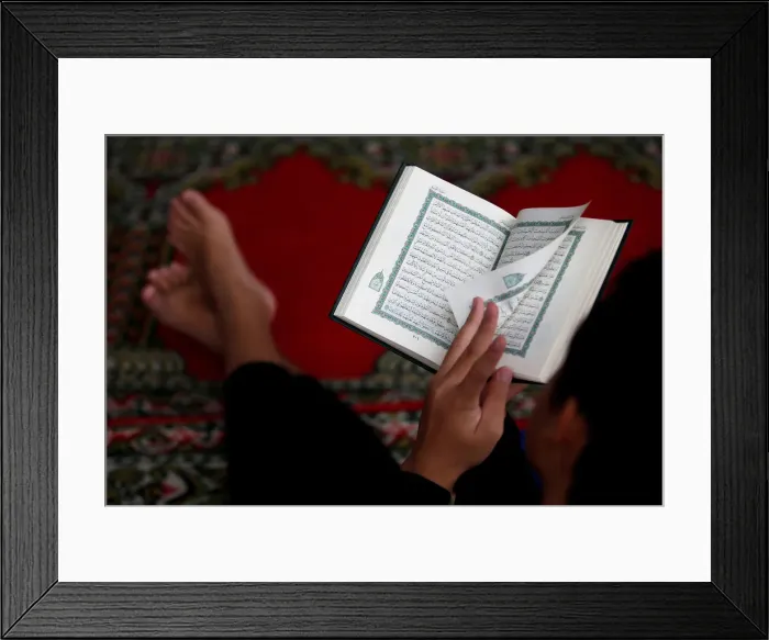 Framed Print : A boy reads the Koran during the holy fasting month of Ramadan at a mosque in Jakarta Framed Print : A boy reads the Koran during the holy fasting month of Ramadan at a mosque in Jakarta