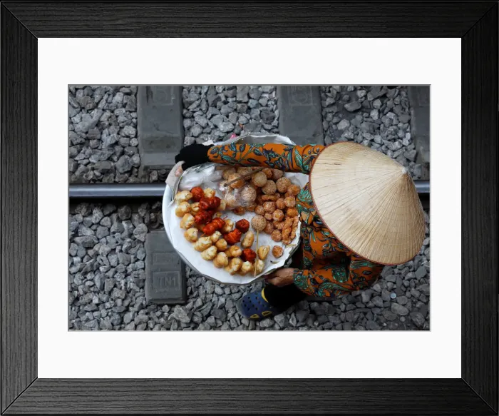 Framed Print : A vendor sells cakes for tourists along a railway in Hanoi Framed Print : A vendor sells cakes for tourists along a railway in Hanoi