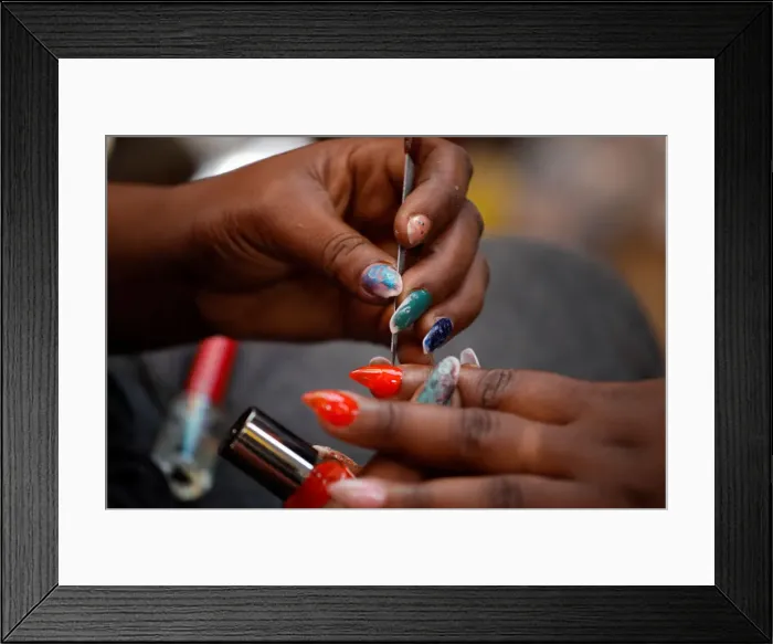 Framed Print : A woman gets a manicure at a street stand in Port-au-Prince Framed Print : A woman gets a manicure at a street stand in Port-au-Prince